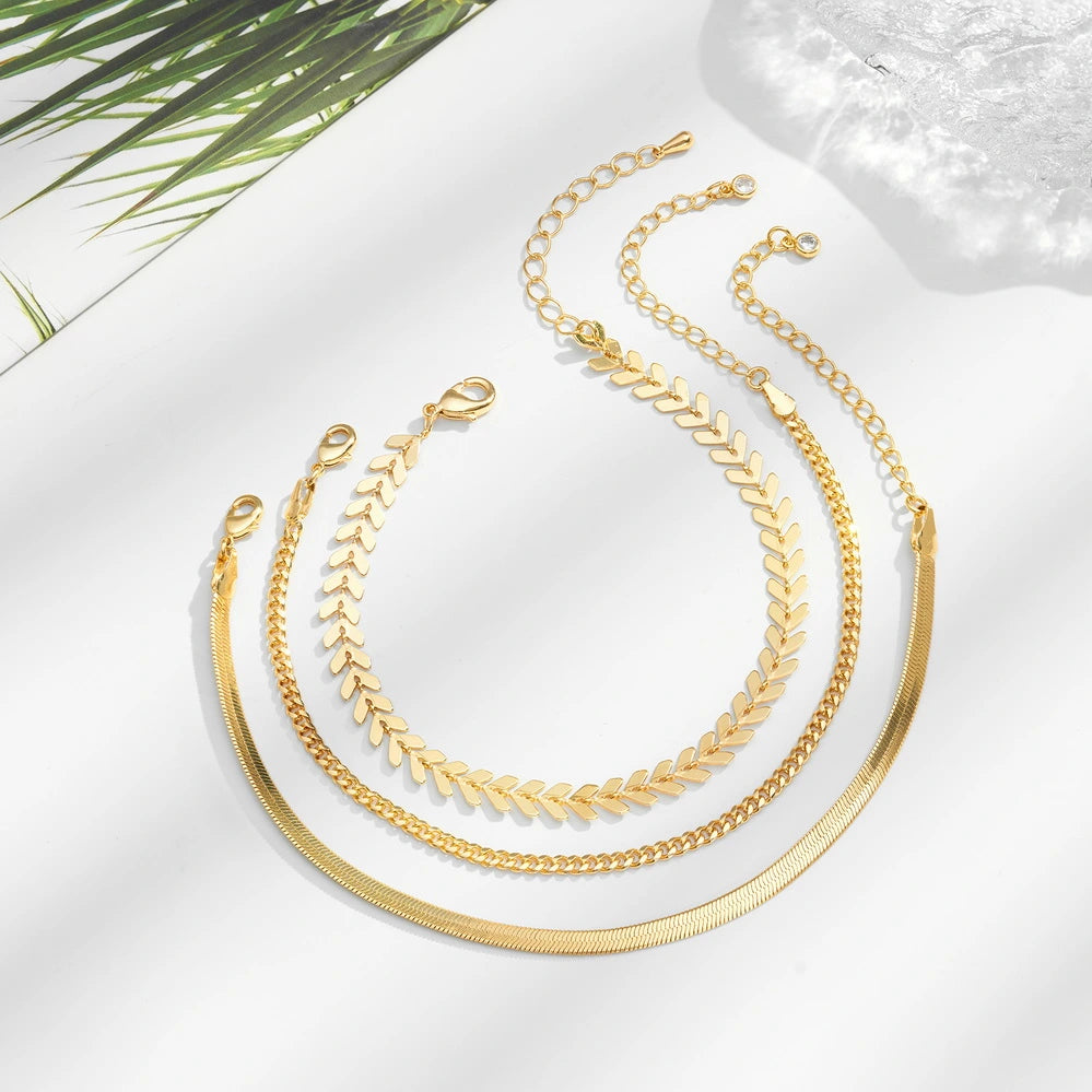 Dainty 14K Gold Plated Layering Anklet Bracelet Set displayed on a jewelry stand